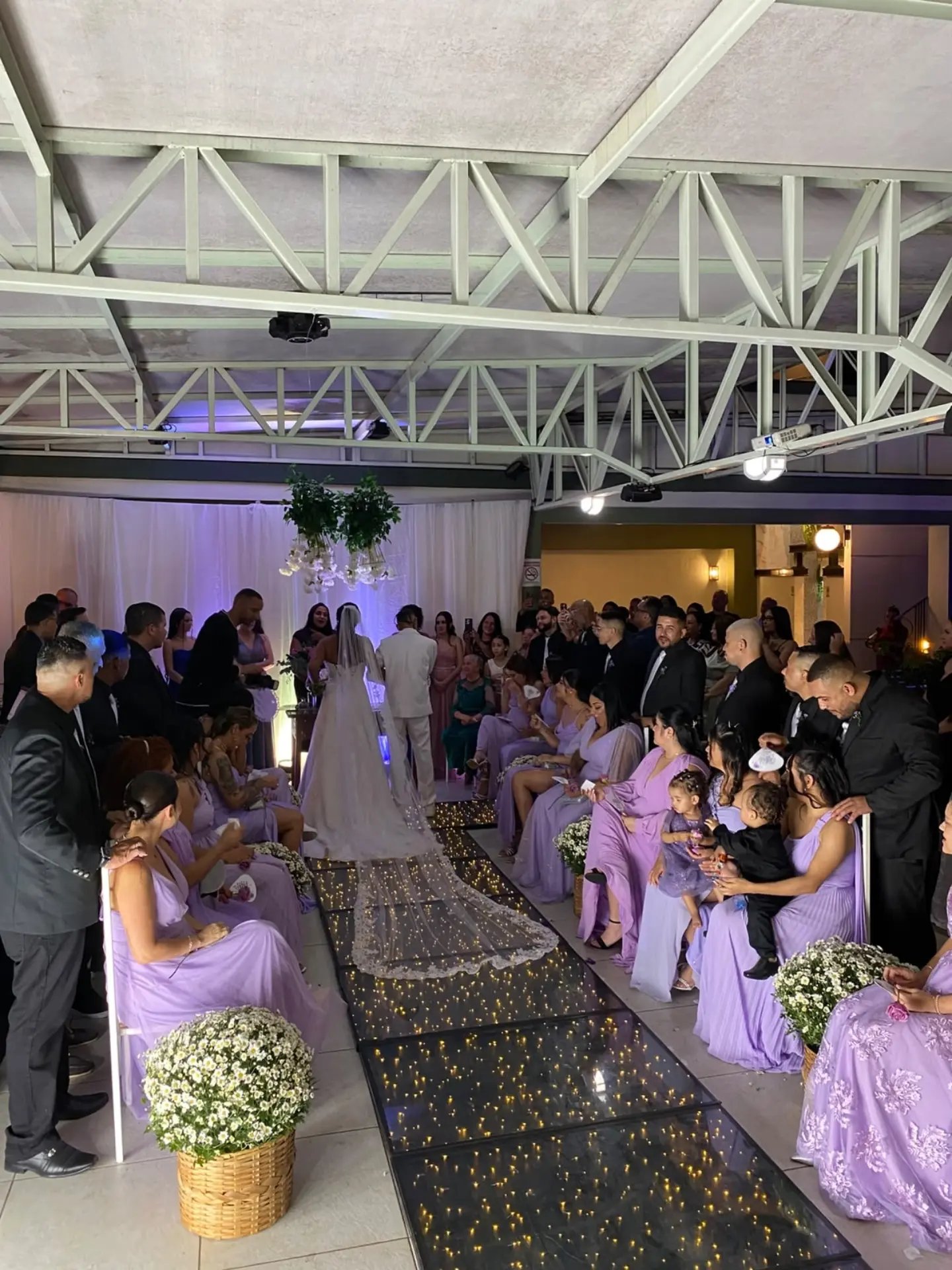 Noiva entrando no salão com os convidados ao redor